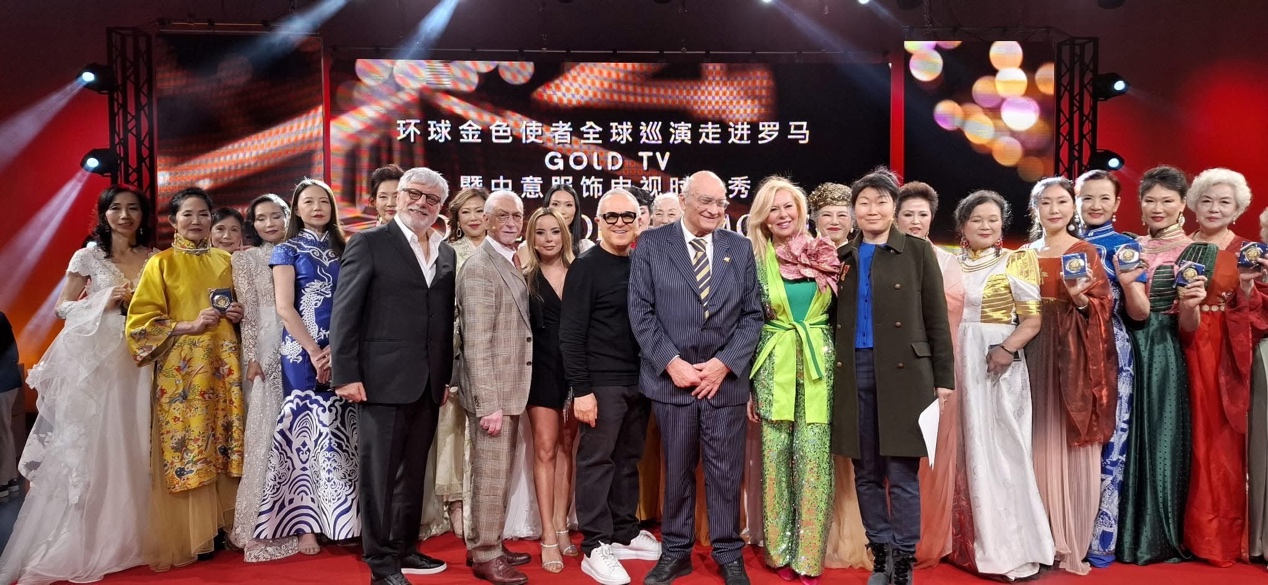 A group of people standing on a red carpet

Description automatically generated